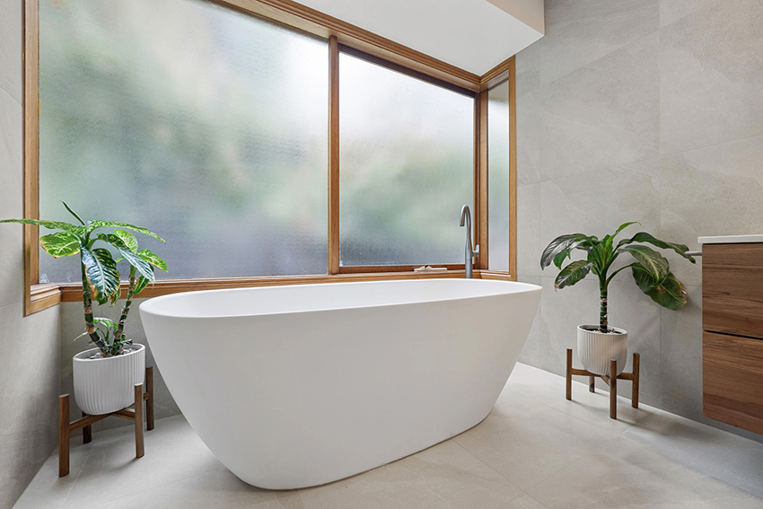 A freestanding bathtub with natural light in a modern bathroom