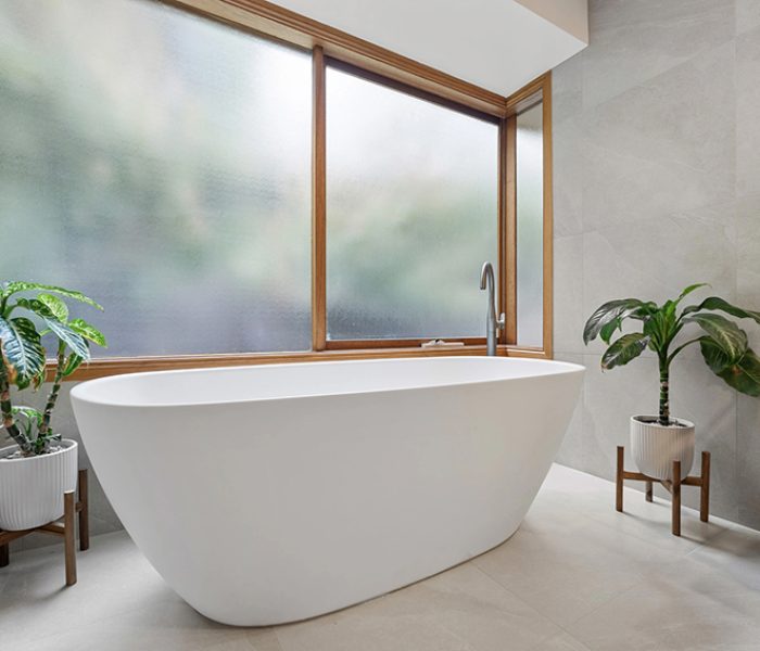 A freestanding bathtub with natural light in a modern bathroom